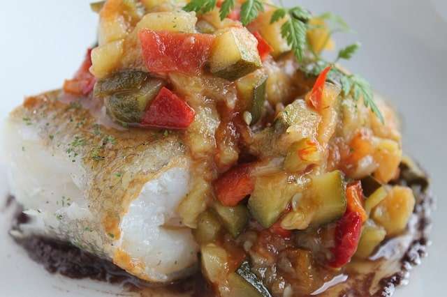 oven baked cod served with roast tomato, herbs and courgette sauce 
