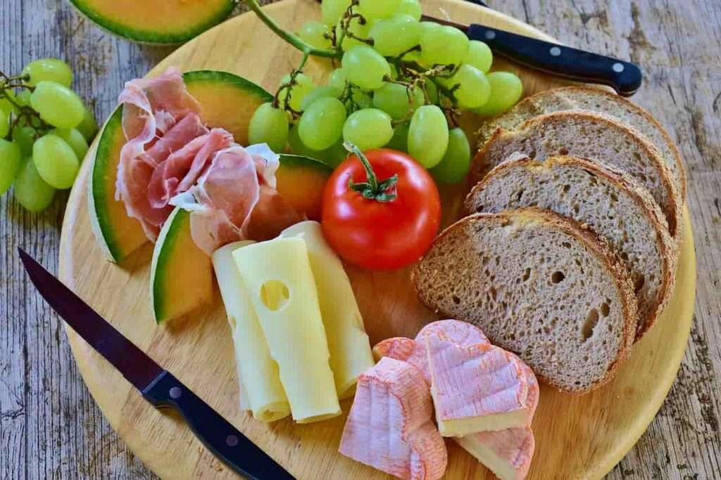 grapes, cheese, Parma ham, Gallia melon and toast board
