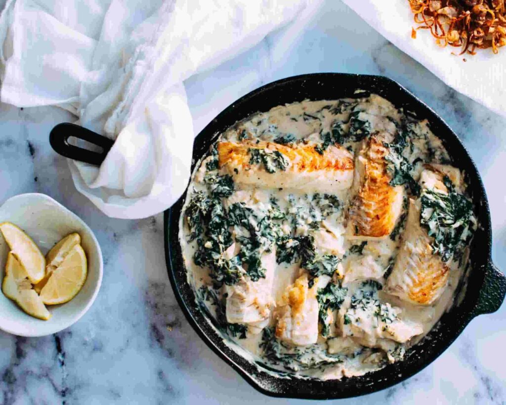 seared hake fillet served in creamy spinach sauce