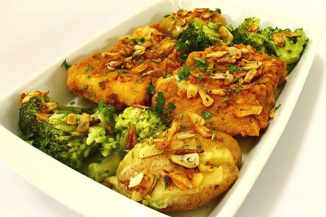 oven baked cod loins with potatoes, broccoli and sliced garlic