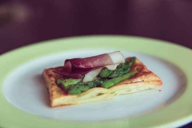 Parma ham, asparagus spears on puff pastry snack dish