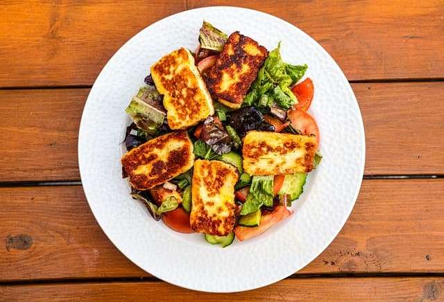 pan fried halloumi served on a bed of mix leaves and fresh slice tomato
