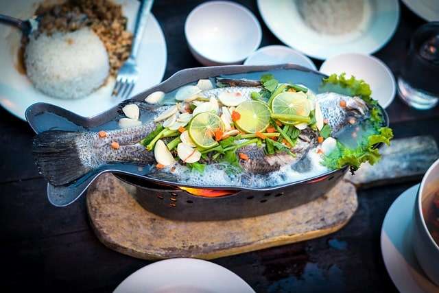 Lime, vegetables and whole fish dish with a side of rice