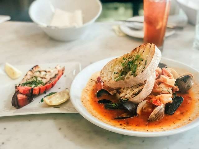 mussels and clams in tomato sauce, served with grilled bread and lobster tail