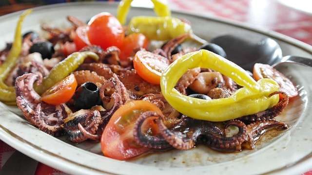 Mediterranean octopus dish with olives, tomatoes and served with pickled chilli 