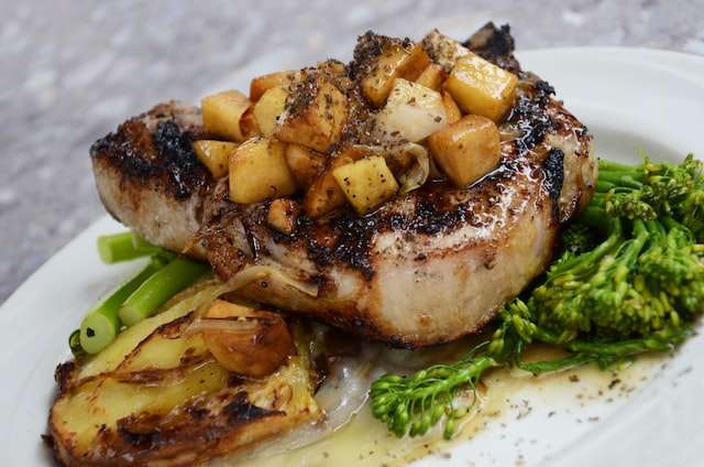 grilled pork chops dish with potato and green vegetables 