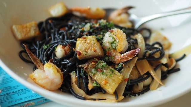 Squid ink pasta with prawns and herbs