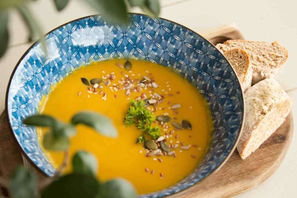 Pumpkin soup with sunflower seeds and greens
